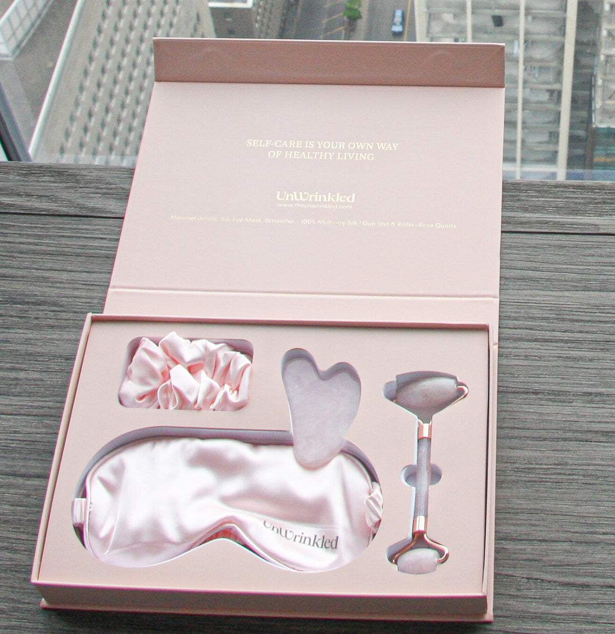 Rose Ritual box open: silk eye mask, scrunchie, gua sha and rose quartz roller