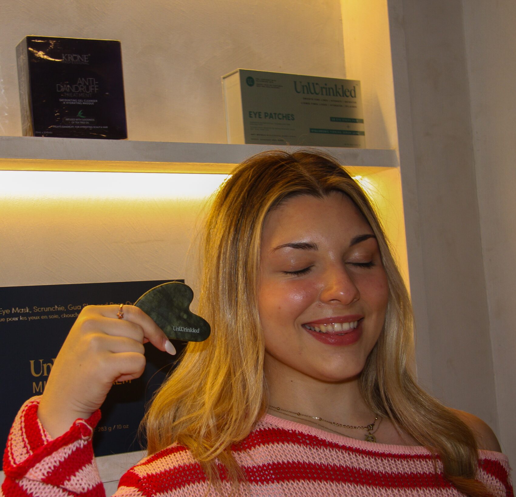 Eyes closed, gua sha along the cheek